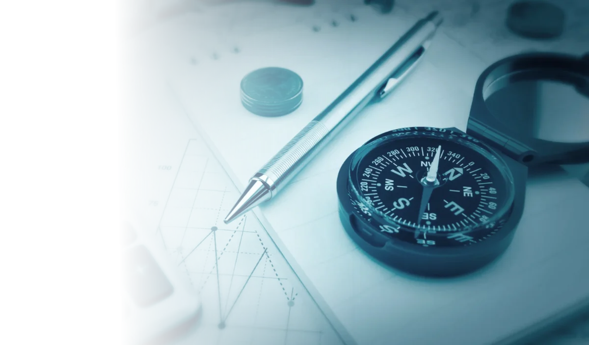 Bússola de navegação e planejamento estratégico sobre planilhas financeiras e gráficos de projeção